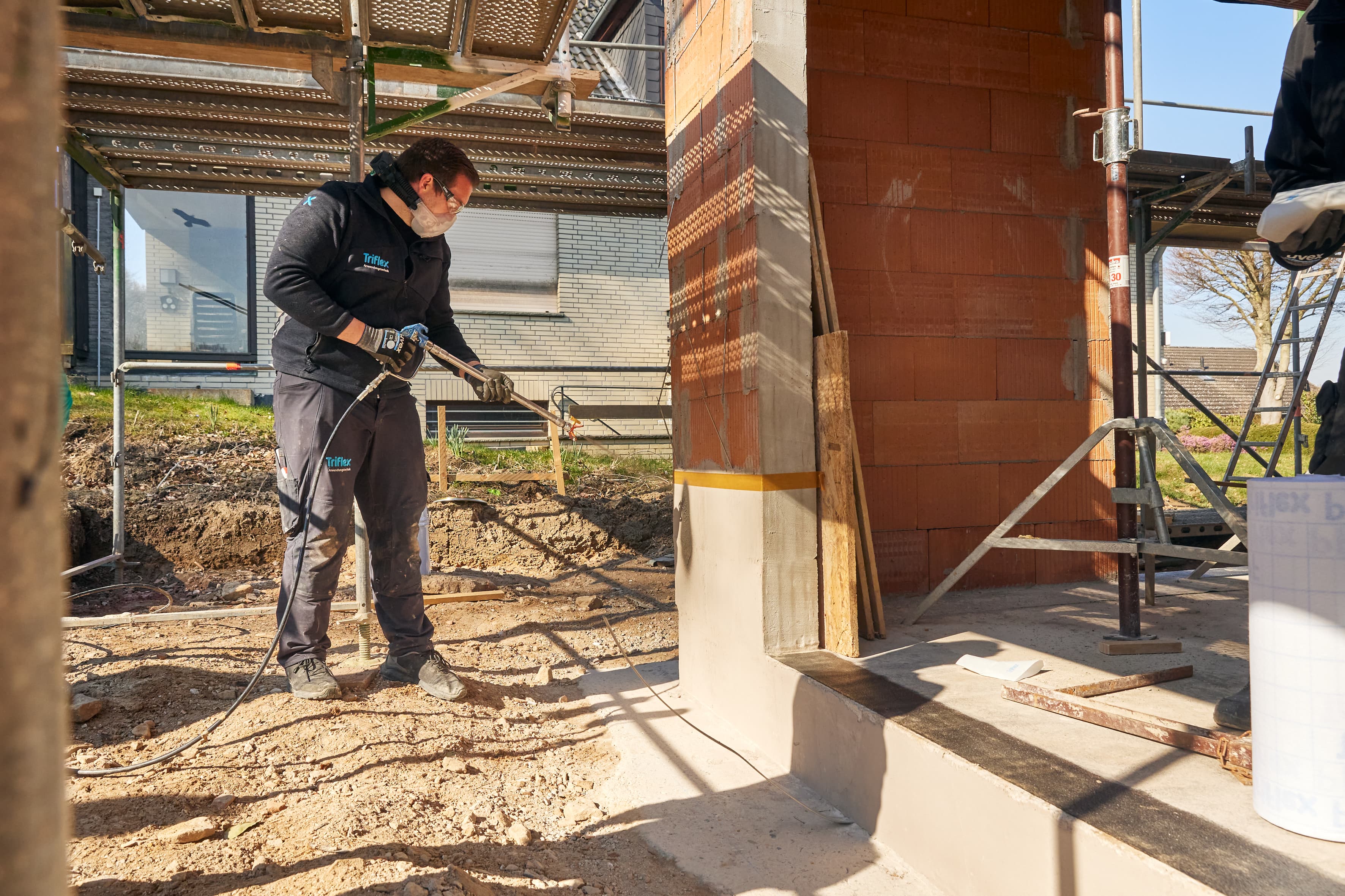 Installation of a liquid-applied waterproofing system at the balcony connection of a building during the construction phase.